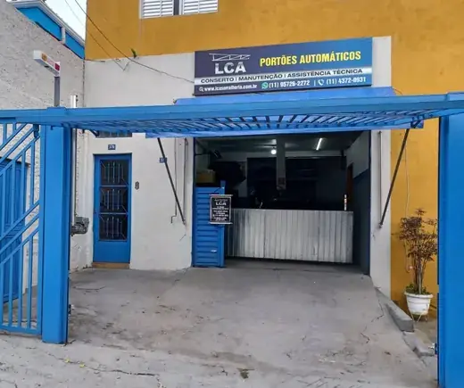 Fachada da oficina da LCA Portões Automáticos na Av. Nova América, 374, em Guarulhos, com portão azul e placa da empresa